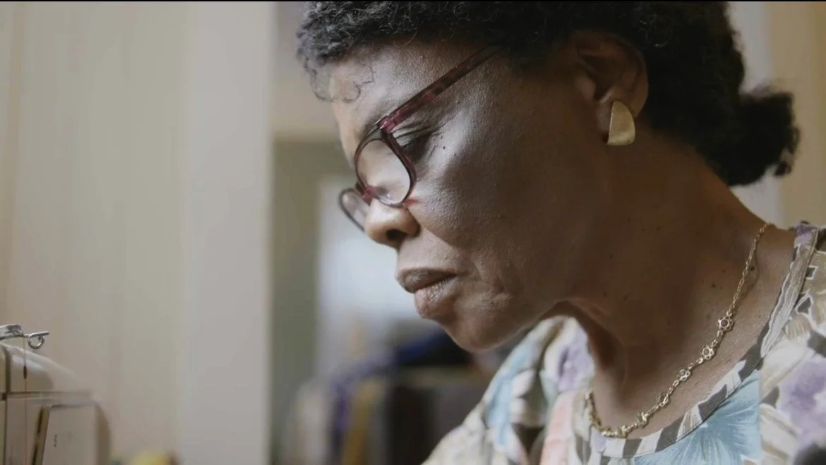 Raymonde Jacquet at a sewing machine in Chante Manman Mwen
