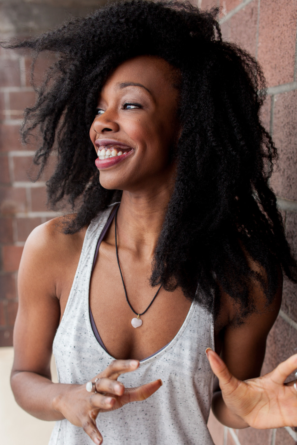 Fedna Jacquet speaking animatedly near a brick wall
